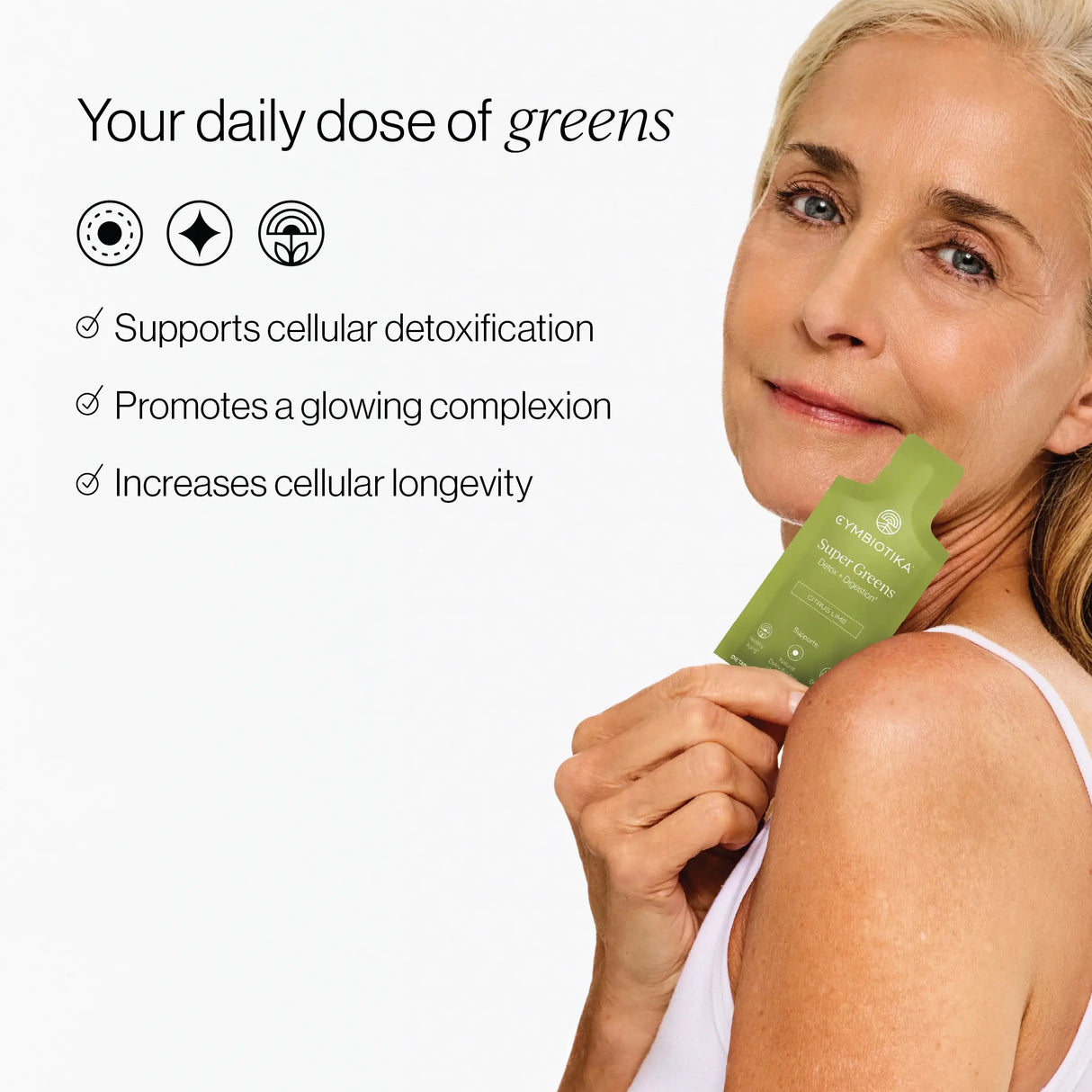 Woman holding a green supplement package with text about its benefits on a white background