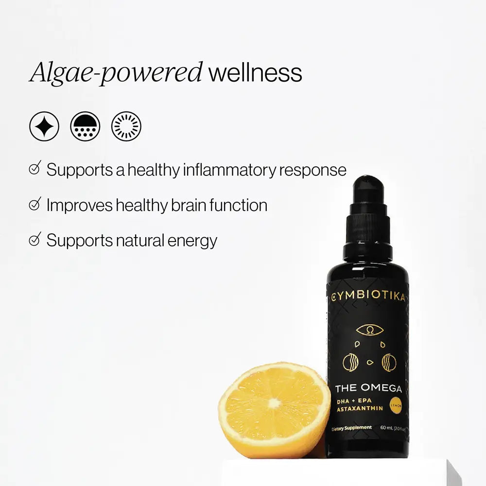 A black dropper bottle labeled Cymbiotika The Omega with a sliced lemon placed beside it on a white background, alongside marketing text about algae-powered wellness.
