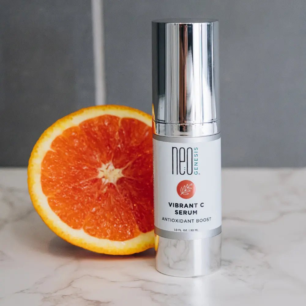 Neogenesis Vibrant C Serum Antioxidant Boost for all skin types next to an orange - Your Skincare Source