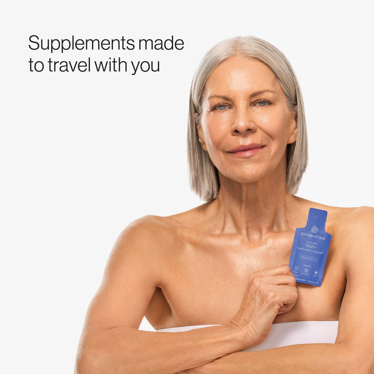 Woman holding a blue supplement bottle with text 'Supplements made to travel with you' on a white background
