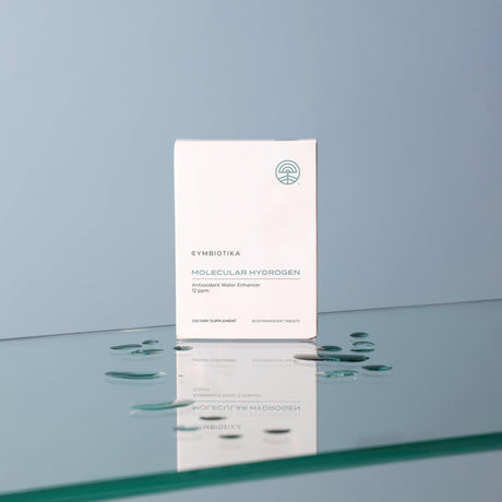 Cynsiotika Molecular Hydrogen skincare product packaging on a reflective surface with a gradient blue background