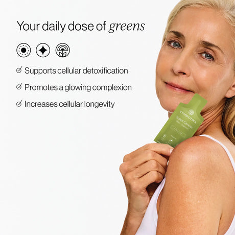 Woman holding a green supplement package with text about its benefits on a white background