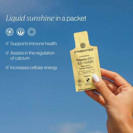 Cymybiotika supplement packet held by a hand against a blue sky background