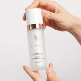 Hands holding a bottle of Elevai Enfinity Exosome Daily Serum, a daily repair serum for aging skin