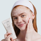 Woman cleansing her face with Face Reality Active Clarity Gel Cleanser while holding the tube