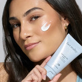 Woman applying sunscreen cream to her face with a 'face reality Daily SPF 30 Plus' product.