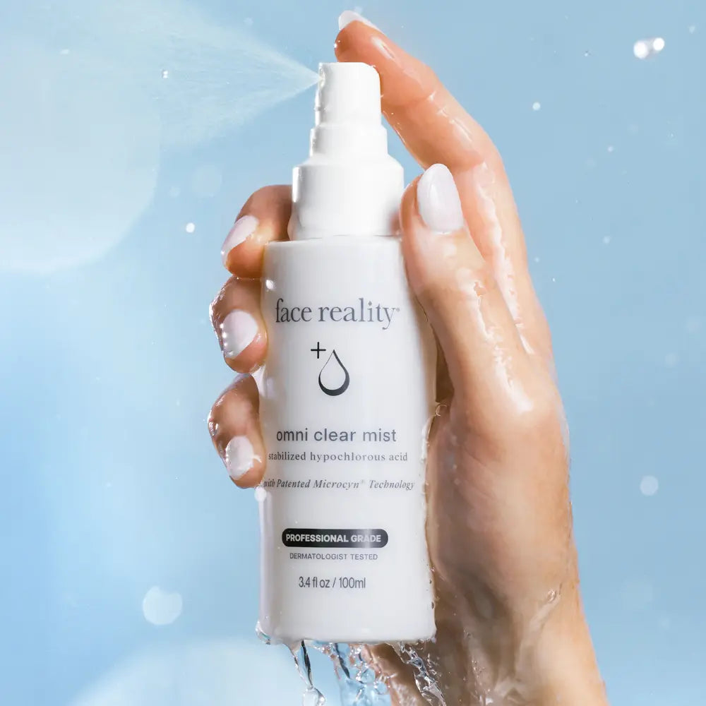 Face Reality Omni Clear Mist bottle with a female hand holding it and spraying it