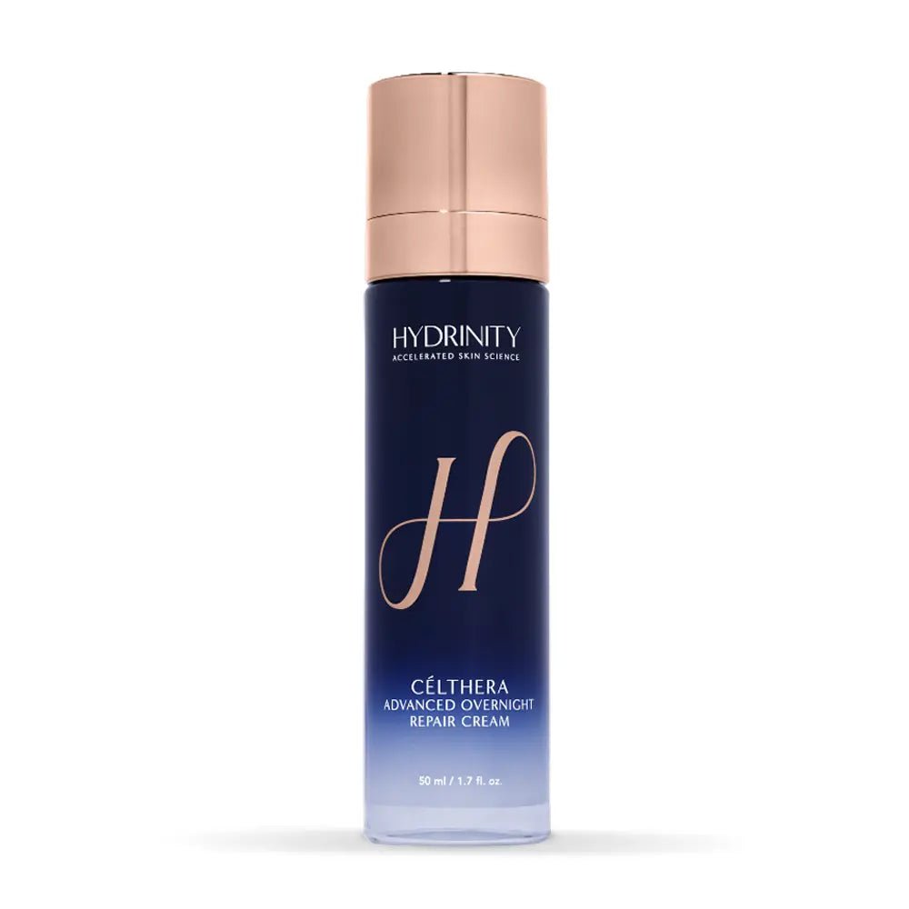 Hydrinity Célthera Advanced Overnight Repair Cream in a tall navy blue bottle with a metallic rose gold cap, shown on a clean white background.