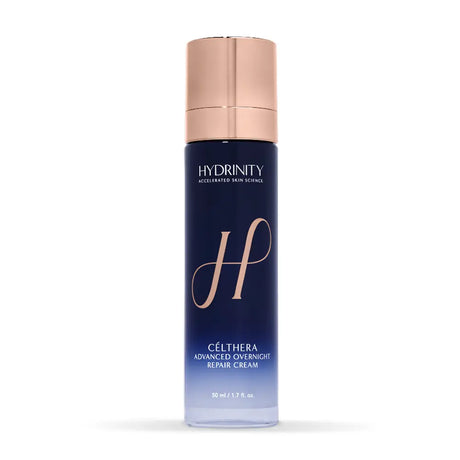Hydrinity Célthera Advanced Overnight Repair Cream in a tall navy blue bottle with a metallic rose gold cap, shown on a clean white background.