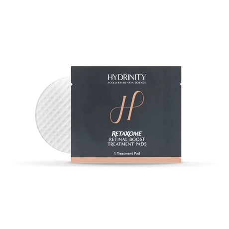 Hydrinity Retaxome Retinal Boost Treatment Pads, featuring a dark charcoal gray single-use pouch with rose gold accents and a single textured white treatment pad visible behind it.