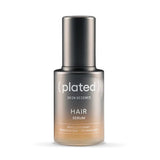 Plated hair serum bottle on a white background