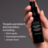 A hand holding a Revision Dermatology Advanced Pigment Corrector+ serum bottle against a dark gray background, with white text on the left listing skin concerns it targets: dark spots, hyperpigmentation, and uneven tone.