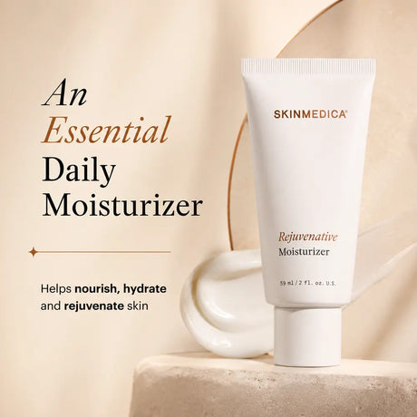 A white tube of  SkinMedica Rejuvenative Moisturizer standing on a stone pedestal, with promotional text on the left reading 'An Essential Daily Moisturizer' and smaller copy about nourishing, hydrating, and rejuvenating skin.