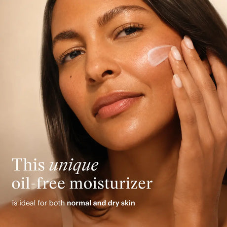 Close-up of a woman applying  SkinMedica Rejuvenative Moisturizer to her cheek, with text reading 'This unique oil-free moisturizer is ideal for both normal and dry skin' on a warm beige background.