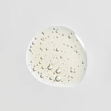 A glossy, translucent droplet of Young Goose Bio-Retinol, centered on a solid light gray background.