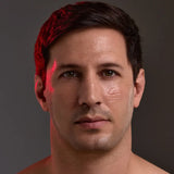 A close-up portrait of a man's face with dramatic red lighting highlighting his hair and cheek with Young Goose L.A.D.R. Serum